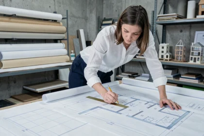 Architecte femme analysant un plan de chambre avec règle et crayon sur table à dessin en studio professionnel